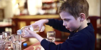 Child learning hand-eye coordination while pouring water.